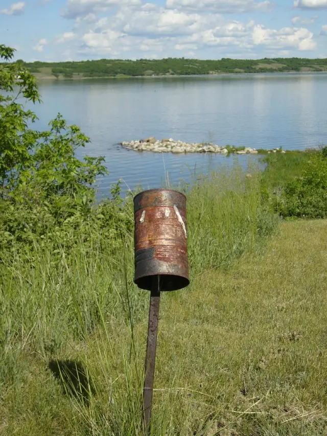 Rusty can on a post by the lake